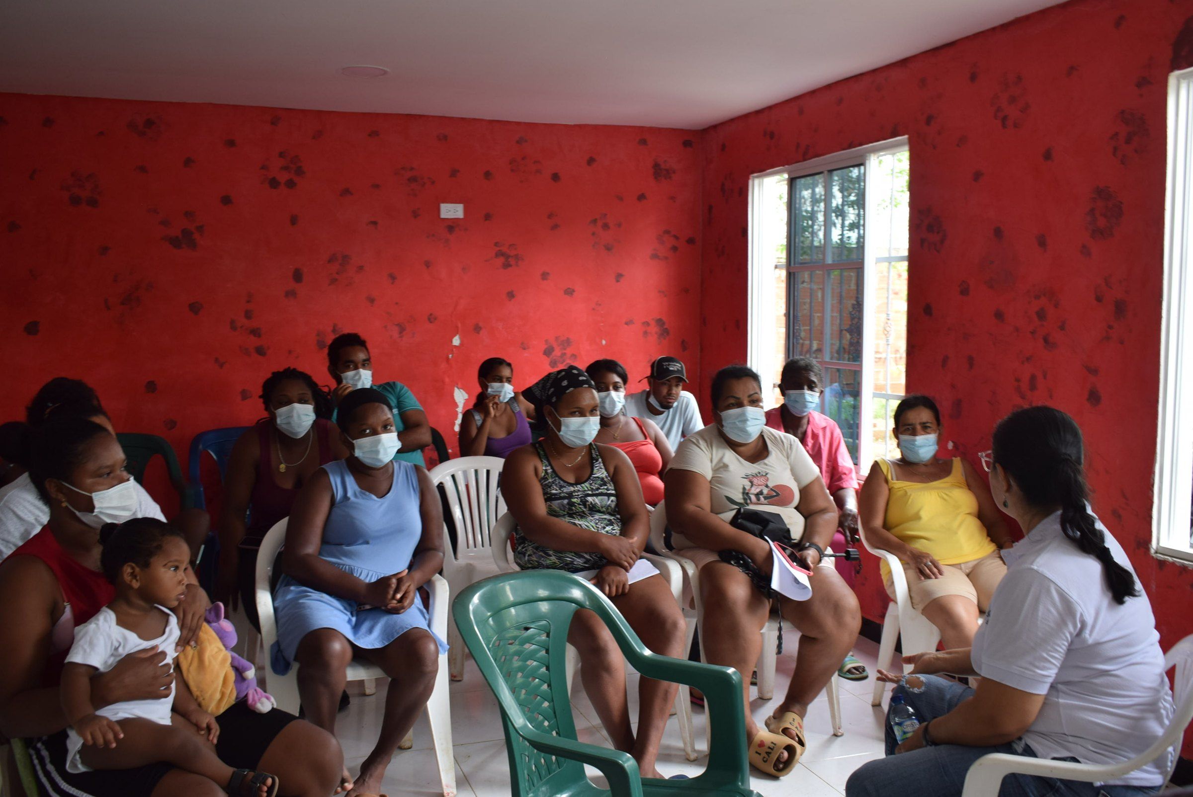 Encuentro comunitario de mujeres, niñas y niños en un salón de Puerto Rey