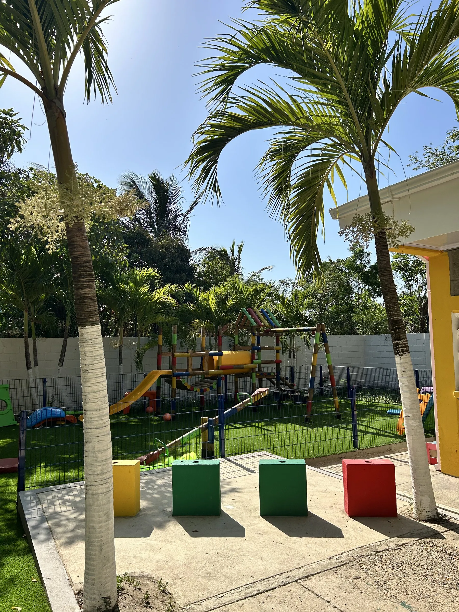 Zona de juegos infantiles con palmeras en Puerto Rey